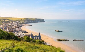 A coastal town with a beach, a church, and a cliff.