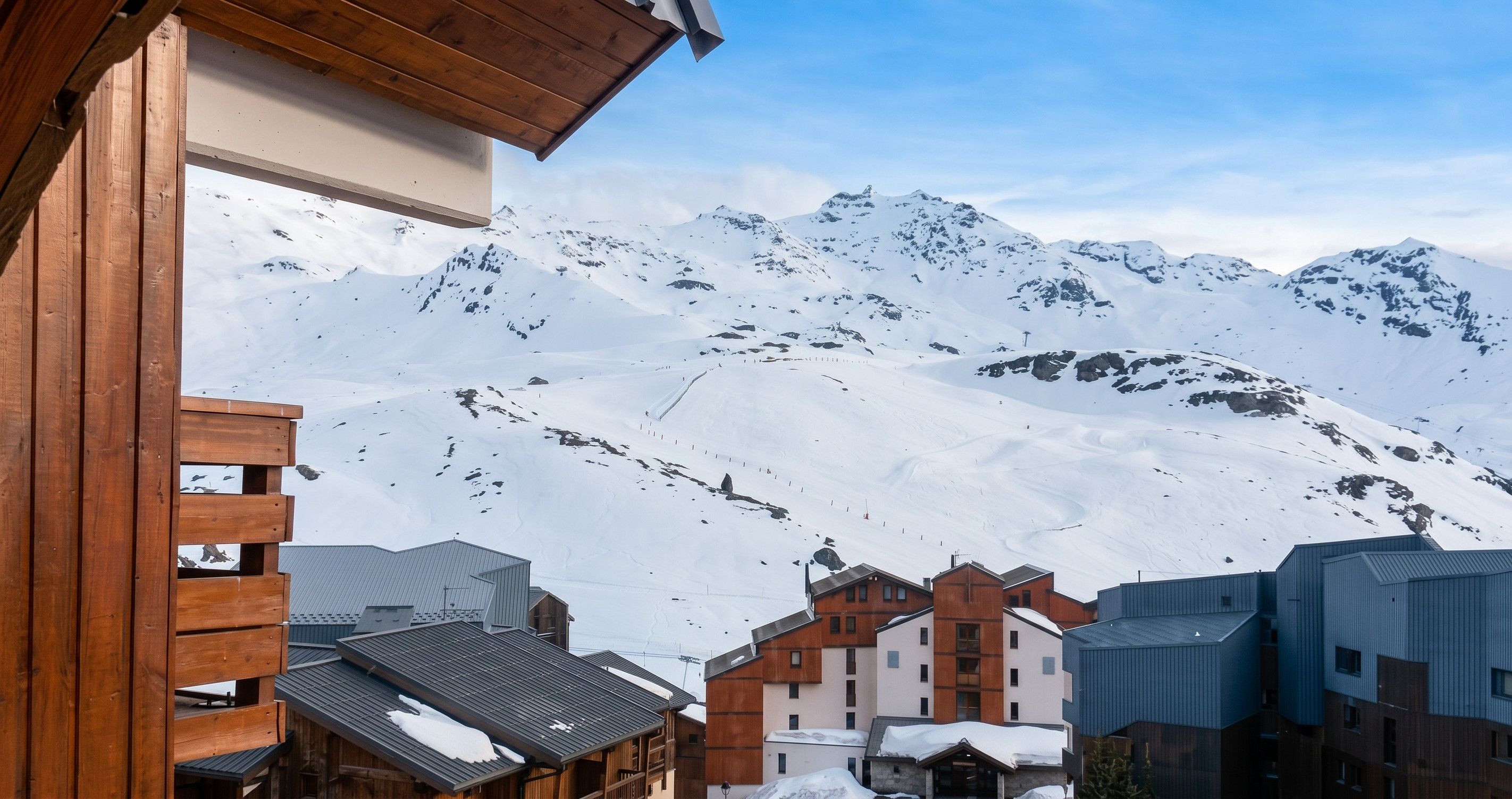 A mountain resort with wooden buildings and a snowy landscape.