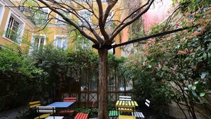 Une cour intérieure avec des sièges en plein air et un arbre au centre.