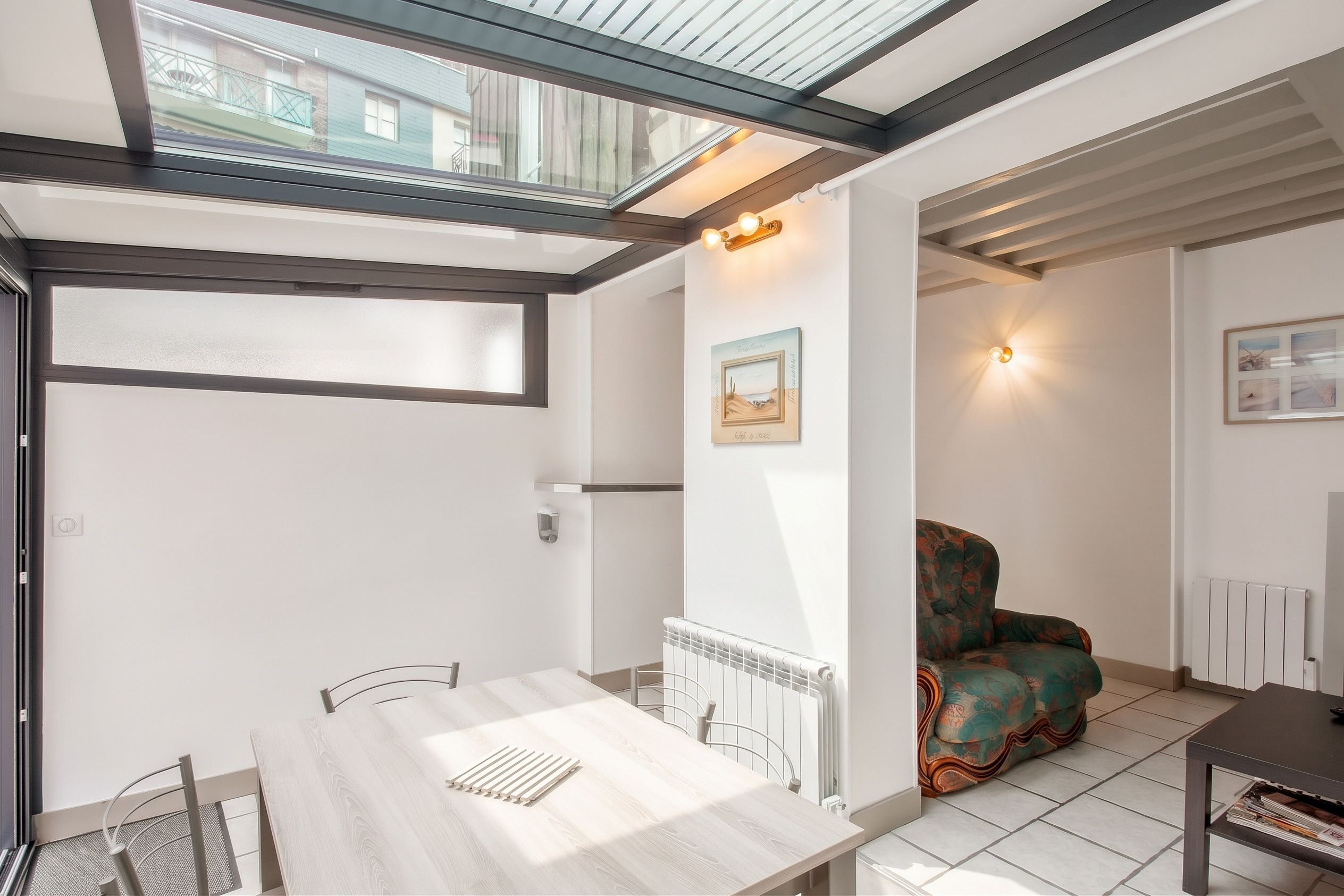 A modern interior with a dining area, a sofa, and a radiator.