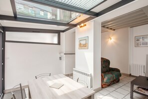 A modern interior with a dining area, a sofa, and a radiator.