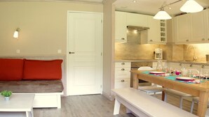 A modern living room with a sofa, a small table with a plant, and a bench. - "Spacious 3-Room Apartment, Ski-In/Ski-Out, Sleeps 7, Forest Hamlet, Les Avanchers-Valmorel" (Valmorel)