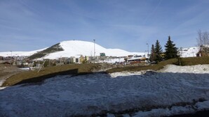 A snowy mountain with buildings in the background.
