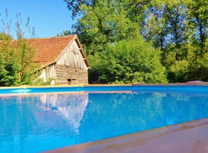 Una piscina con una estructura de madera al fondo.