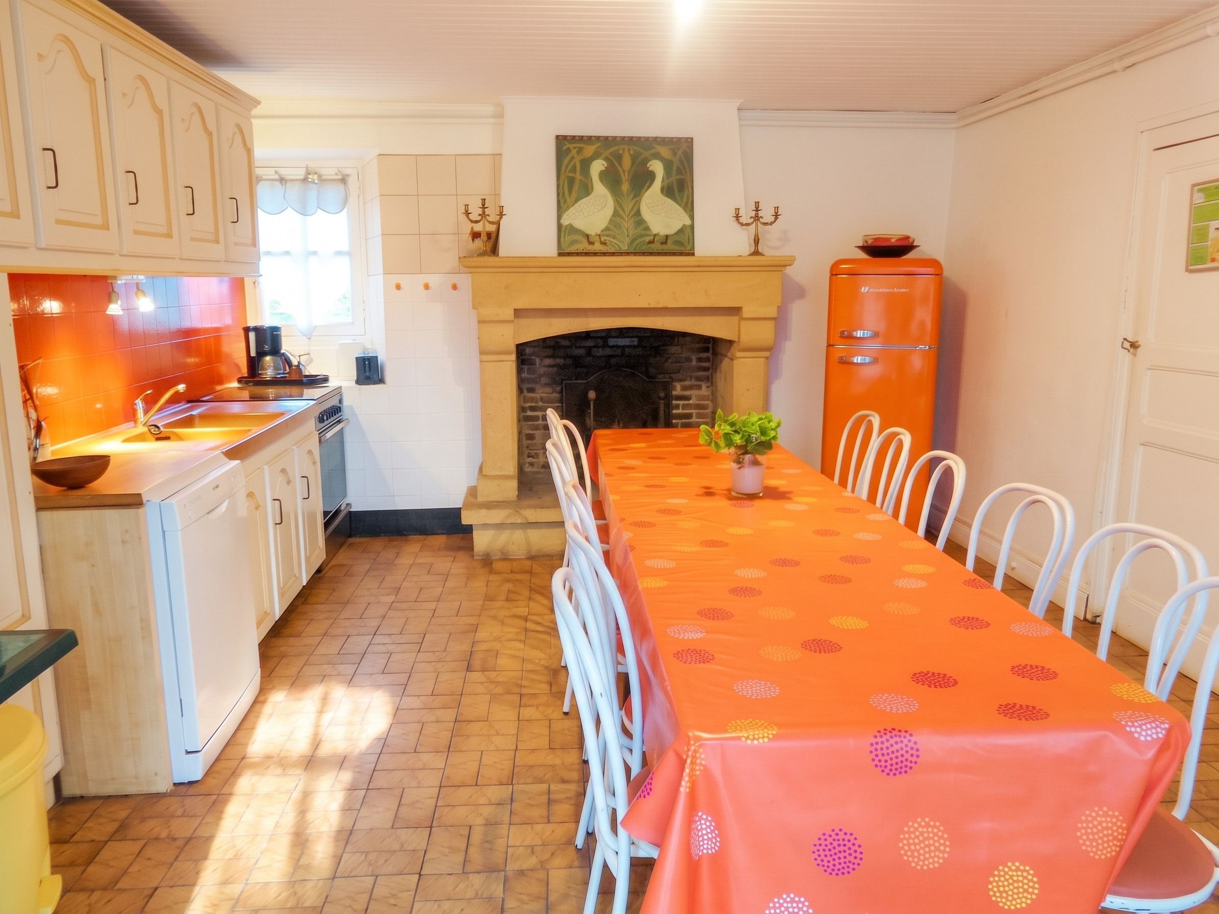 Une cuisine avec un coin repas, une cheminée et un réfrigérateur.