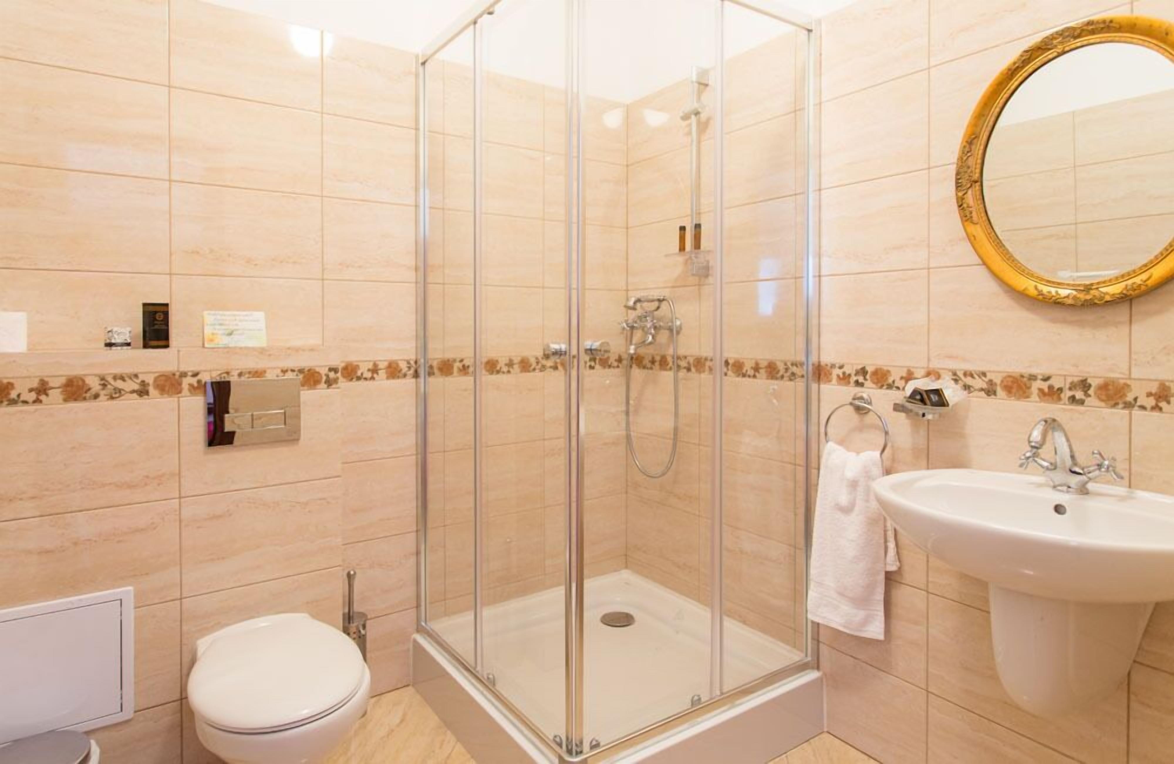 A bathroom with a glass-enclosed shower, a sink, and a toilet.
