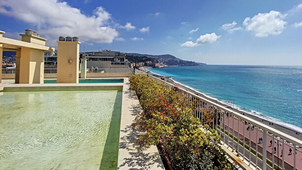 A rooftop pool with a view of the sea and buildings in the background. - N&J - SUITE ROYAL LUXEMBOURG - Rooftop pool (Niza)