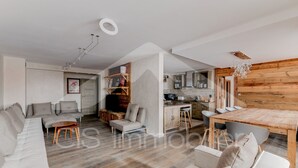 Una sala de estar moderna con un sofá, una mesa de comedor y una zona de cocina.