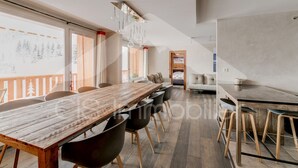 Un comedor moderno con una mesa de madera larga, sillas negras y un banco de madera.