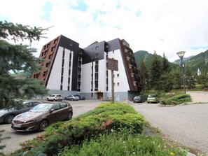 A modern building with a unique architectural design, featuring a mix of white and brown panels and multiple windows.