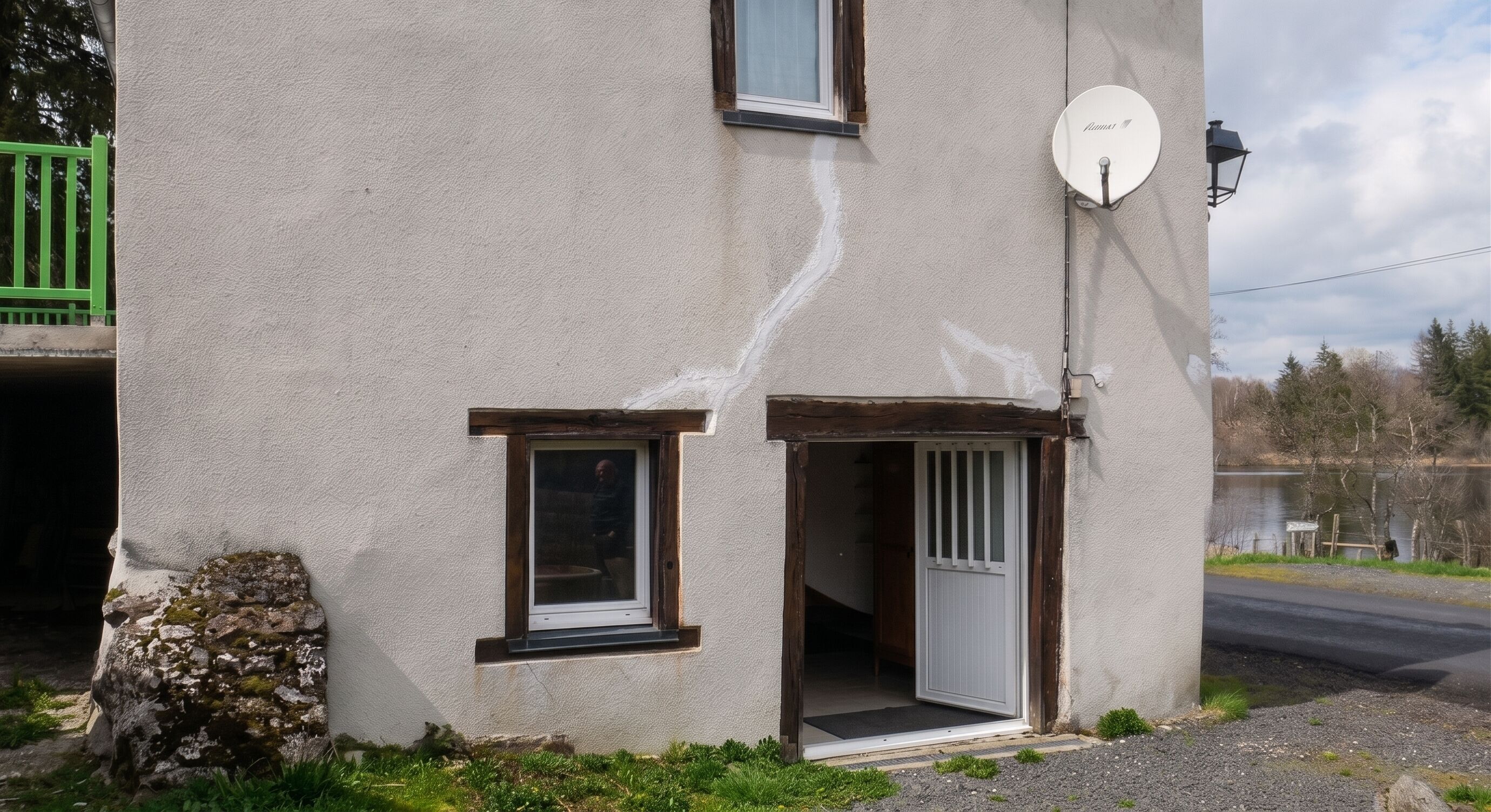 A building with a satellite dish, a window, and a door.