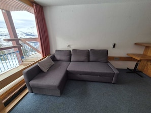 A modern living room with a sectional sofa, a wooden bench, and a view of a snowy mountain. - Studio for 5 with Wifi and pets allowed in Arc 1800 (Les Arcs 1800)