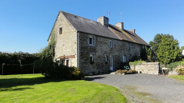 A stone building with a sloped roof, a front entrance, and a paved driveway. - Cozy Stone Farmhouse with Garden, Near Saint-Lô – Sleeps 4, Modern Amenities, Pet-Friendly (Baudre)