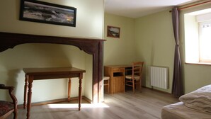 A room with a wooden desk, a chair, a bed, and a window with curtains. - Cozy Stone Farmhouse with Garden, Near Saint-Lô – Sleeps 4, Modern Amenities, Pet-Friendly (Baudre)