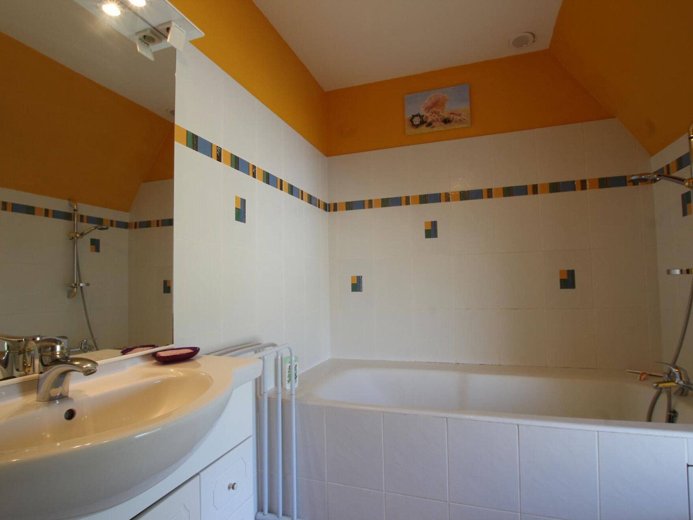 Een badkamer met een bad, een wastafel en een spiegel.