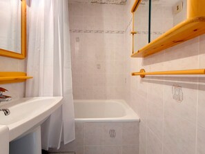 Ein Badezimmer mit Badewanne, Waschbecken und Spiegel.