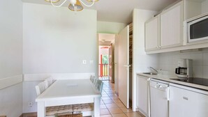 A compact kitchen with white cabinets, a microwave, and a coffee maker.