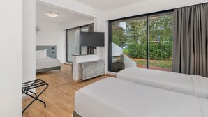 A modern hotel room with a large bed, a TV mounted on the wall, and a view of the outdoors. - B&B Hotel Alba (Alba)