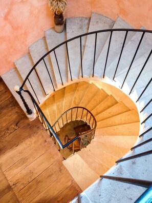 A spiral staircase with a metal railing and wooden steps.