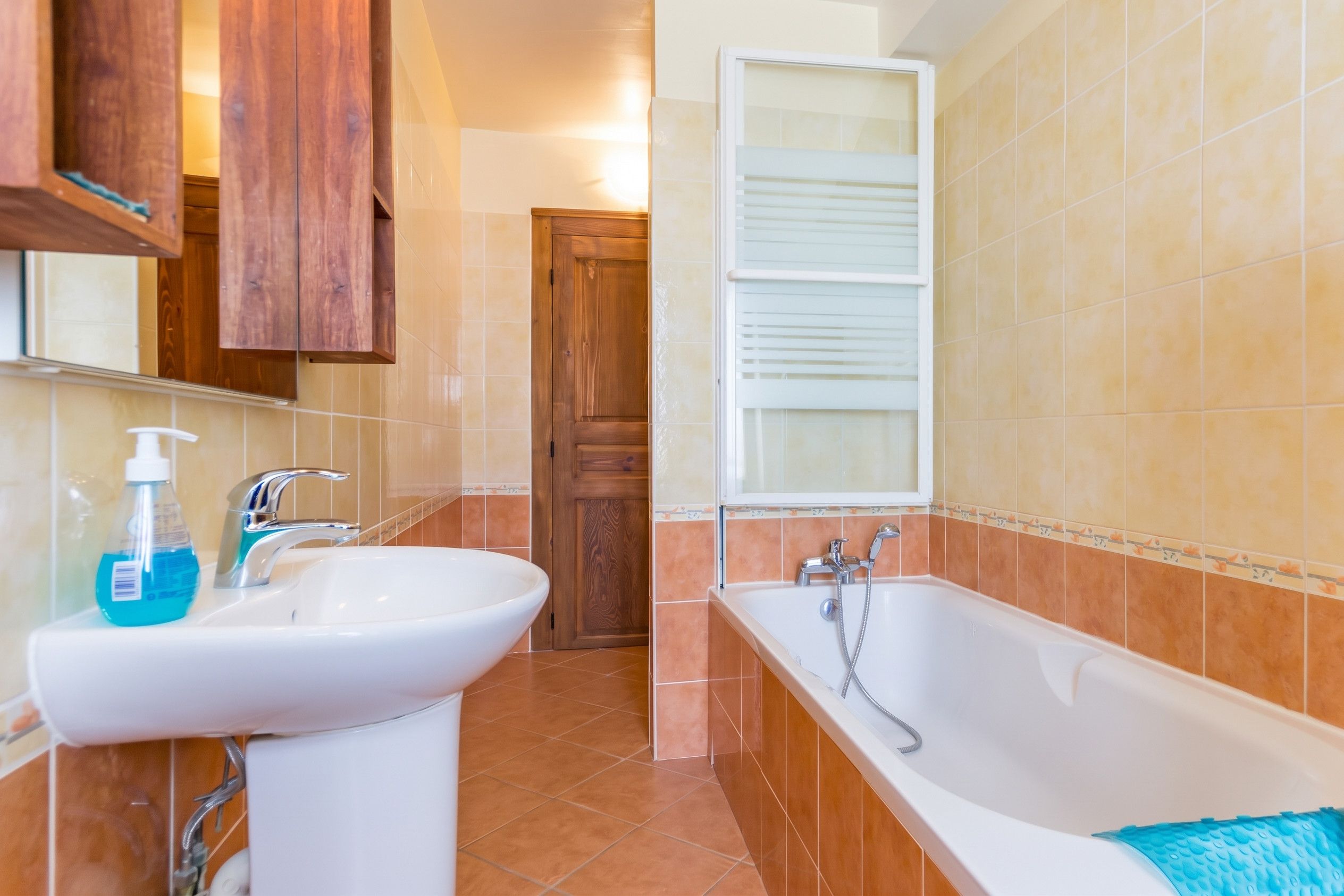 A bathroom with a sink, faucet, and a bathtub with a showerhead.