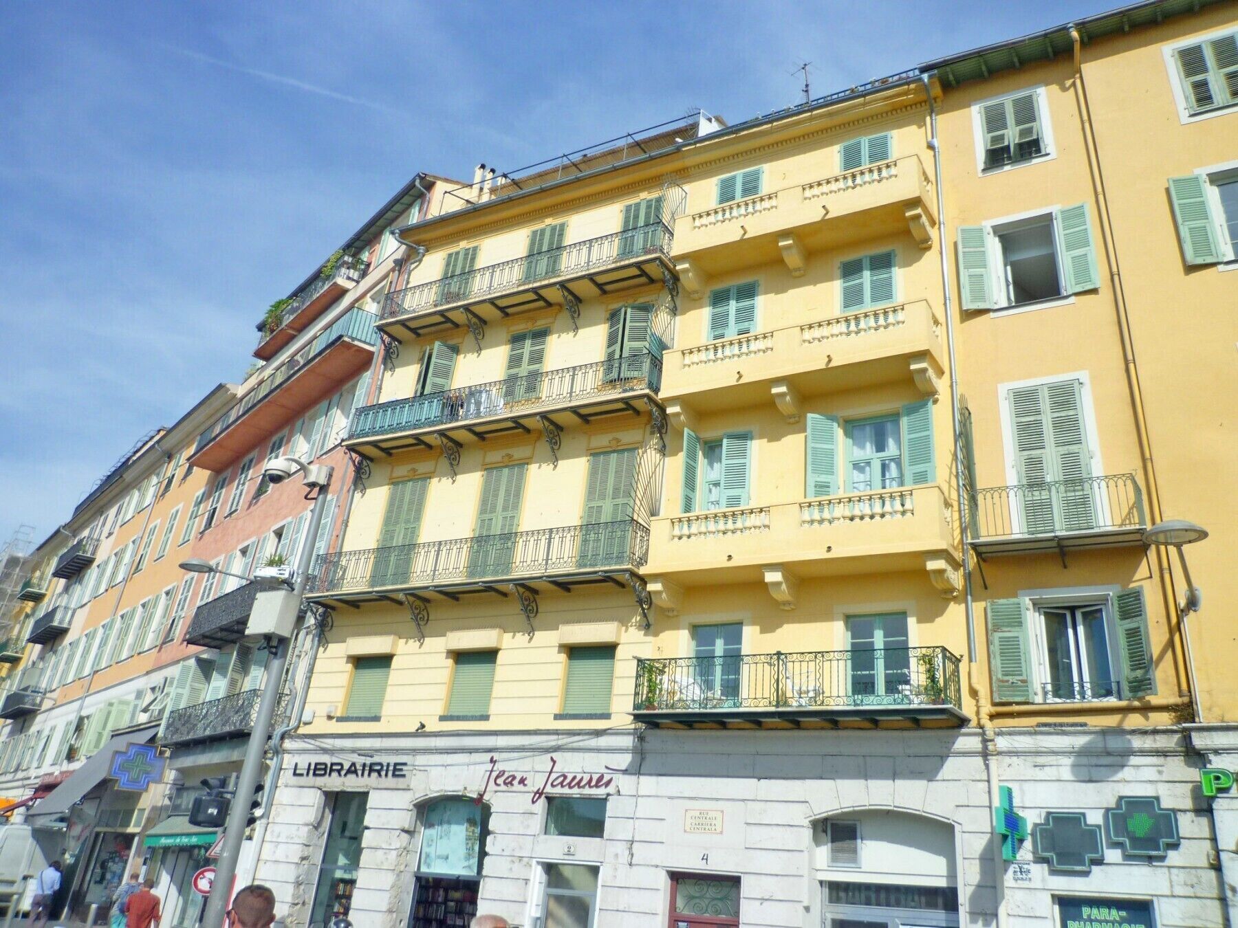 A multi-story building with balconies, a pharmacy, and a library.