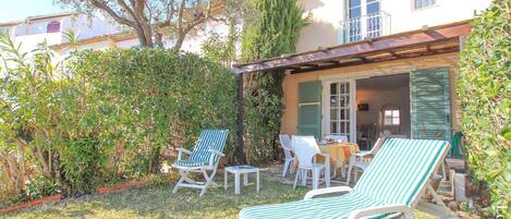 Un patio con dos sillones, una mesa y una silla.