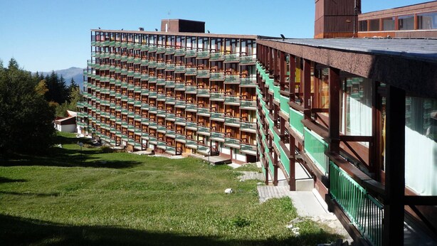 A modern hotel with a unique modular design, featuring multiple balconies and a prominent green facade. - Ski-in studio for 5, pets allowed at Arc 1800 (Les Arcs 1800)