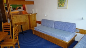 A small, cozy room with a wooden bench, a small table, and a kitchenette area. - Ski-in studio for 5, pets allowed at Arc 1800 (Les Arcs 1800)