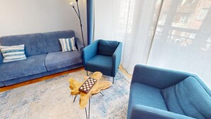 A modern living room with a sofa, two armchairs, a coffee table, and a floor lamp. - netter 70m2 city center    2br (Strasbourg)