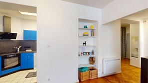 A modern kitchen with blue cabinets, a built-in oven, and a white refrigerator. - netter 70m2 city center    2br (Strasbourg)