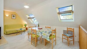 A dining area with a table, chairs, and a sofa. - Homerez - Comfort apt Arzon (Arzon)