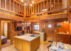 A spacious kitchen with a central island, upper-level seating, and a dining area with a table set for four.