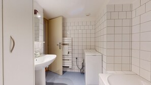 Bathtub, hair dryer, towels, toilet paper