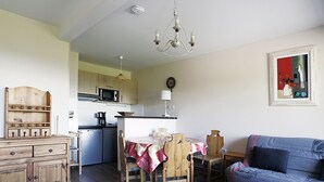 A compact living space with a dining area, kitchenette, and a sofa. - Apartment 6 ppl, balcony, ski-in/ski-out, parking, spa - Peyragudes (Peyragudes)