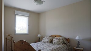A bedroom with a wooden bed, two bedside lamps, a window, and a wooden nightstand. - Apartment 6 ppl, balcony, ski-in/ski-out, parking, spa - Peyragudes (Peyragudes)