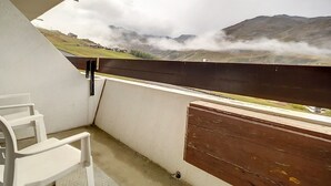A balcony with a view of a mountainous landscape and a wooden fence. - Bright ski-in/ski-out duplex, balcony, 4 ppl (Les Menuires)