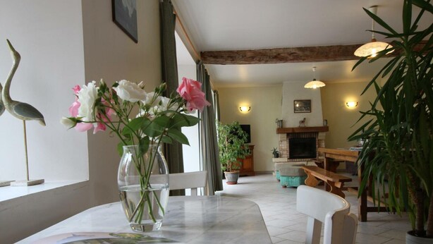 A living room with a marble table, a vase with flowers, a fireplace, and a television. - Bright house with fireplace and enclosed garden (Le Plessis-Lastelle)