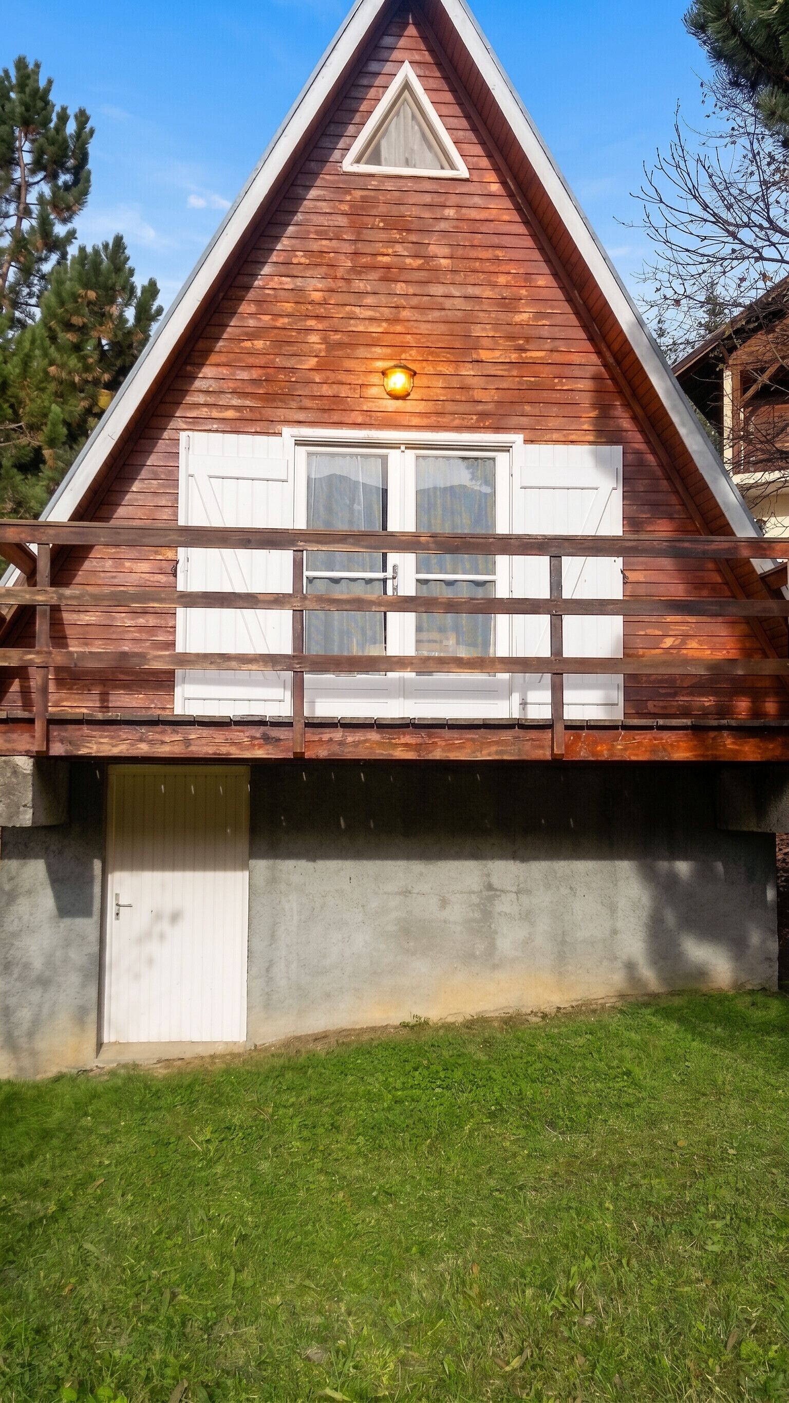 Une maison en bois avec un balcon, une fenêtre et une porte.