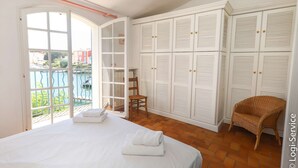 Une chambre à coucher avec un lit, une chaise, une armoire et une vue sur l’extérieur.