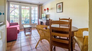 Ein gemütliches Wohnzimmer mit Essbereich, großen Fenstern und Kamin.