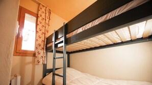A bunk bed room with a window and a radiator. - 3-room apartment, 6 pers, balcony, pets allowed, optional parking (Valmorel)
