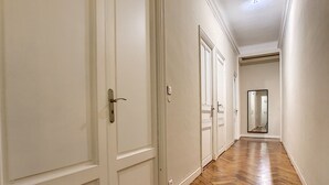 Un couloir avec des portes blanches et un plancher en bois.
