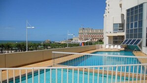 A rooftop pool with clear views of the ocean and a historic building in the background. - Charming downtown studio with pool near Grande Plage (Biarritz)