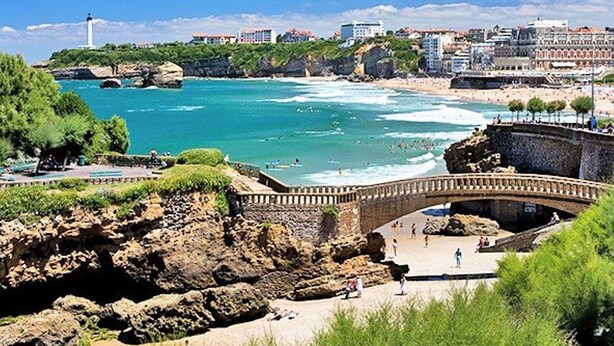 A coastal view with a stone bridge, rocky cliffs, and a beach with people. - Charming downtown studio with pool near Grande Plage (Biarritz)