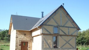 A traditional half-timbered house with a stone foundation, a pitched roof, and a chimney. - Charming cottage with Internet near Mont Saint-Michel (Les Chambres-Le Grippon)