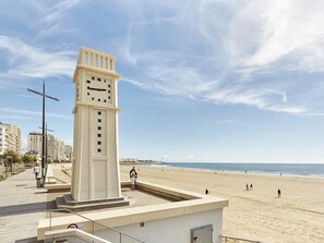 A clock tower with a clear view of the beach and ocean in the background.
