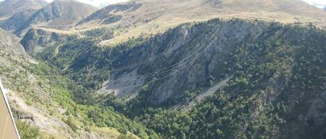 A mountainous landscape with a valley and a road.