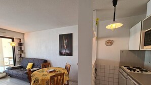 A living room with a sofa, a dining table with chairs, a bookshelf, and a painting on the wall.