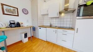 A modern kitchen with white cabinets, a wooden countertop, a built-in oven, and a coffee maker. - kiener 75m2 city center      3br (Colmar)