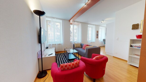 A modern living room with a sofa, red armchairs, a coffee table, and a TV. - kiener 75m2 city center      3br (Colmar)